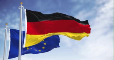 Açık bir günde Almanya ve Avrupa Birliği bayrakları dalgalanıyor. Almanya 1958 yılında AB üyesi oldu. Kusursuz 3 boyutlu animasyon. Yavaş çekim döngüsü. Seçici odaklanma. Kanat çırpan kumaş. 4k
