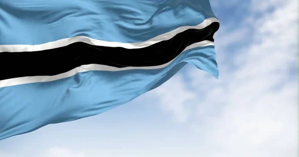 National flag of Botswana waving in the wind on a clear day. Light blue field with a horizontal black and white stripe in the center. 3d illustration render. Fluttering fabric