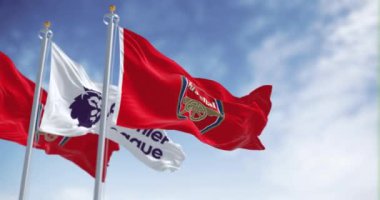 Londra, İngiltere, 18 Temmuz 2023: Arsenal Futbol Kulübü ve Premier Lig bayrakları açık bir günde dalgalanıyor. Kusursuz 3 boyutlu animasyon. Yavaş çekim döngüsü. Seçici odaklanma. Kanat çırpan kumaş. 4k