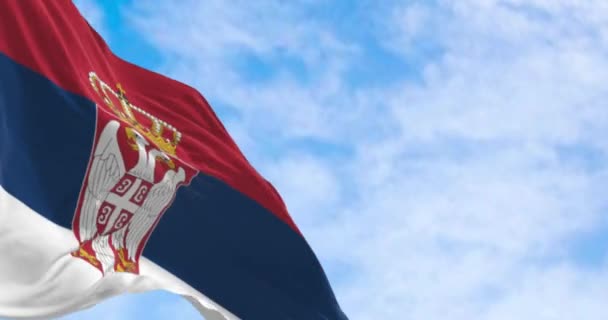 セルビアの国旗は 晴れた日に風を振っています ホイストの腕のコートが付いている赤 青および白い縞 シームレス3Dレンダリングアニメーション スローモーションループ 選択的な焦点 4Kについて — ストック動画