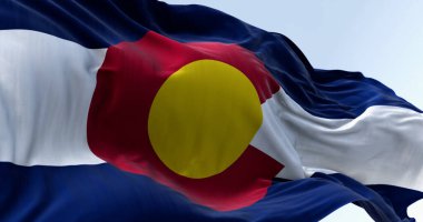 Colorado eyaletinin açık bir günde rüzgarda dalgalanan bayrağının yakın çekimi. Üç mavi, beyaz ve mavi şerit. Üstünde altın diski olan kırmızı C. 3 boyutlu illüstrasyon. Çırpınan kumaş