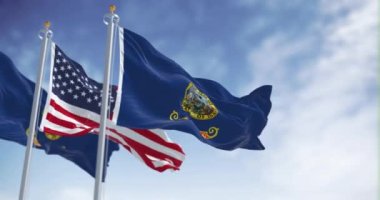 Idaho eyalet bayrağı açık bir günde Amerika Birleşik Devletleri bayrağıyla birlikte dalgalanıyor. Kusursuz 3 boyutlu animasyon. Yavaş çekim döngüsü. Seçici odaklanma. 4k