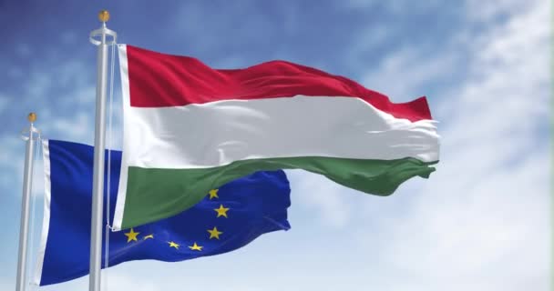 ハンガリーとヨーロッパ連合の国旗は 晴れた日に手を振った ハンガリーは2004年に欧州連合の加盟国となった シームレス3Dレンダリングアニメーション スローモーションループ 4Kについて — ストック動画