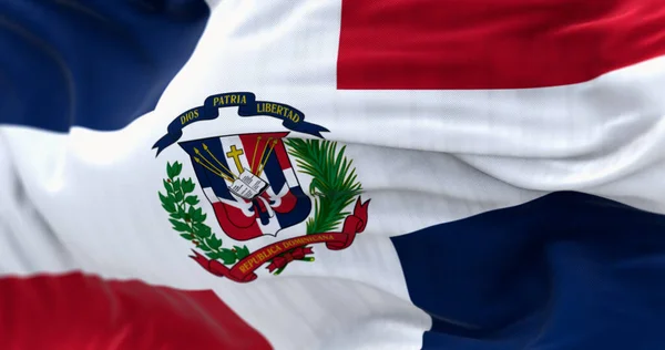 ドミニカ共和国の旗の閉鎖 赤と青の旗と白い十字架 中央に腕のコート 3Dイラストレンダリング リップした生地 テクスチャされた背景 選択的なフォーカス — ストック写真