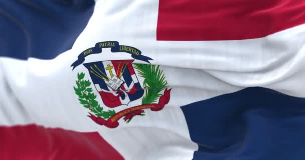 ドミニカ共和国の旗の閉鎖 赤と青の旗と白い十字架 中央に腕のコート シームレス3Dレンダリングアニメーション スローモーションループ 選択的な焦点 4Kについて — ストック動画