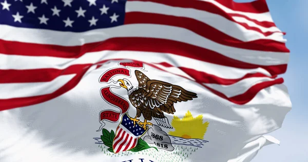 The Illinois state flag waving with the national flag of the United States of America on a clear day. 3D illustration render. Fluttering fabric. Selective focus
