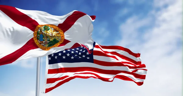 Flags of Florida and United States waving in the wind on a clear day. Florida is a state in the southeastern US. US federate state. 3d illustration render. Fluttering textile