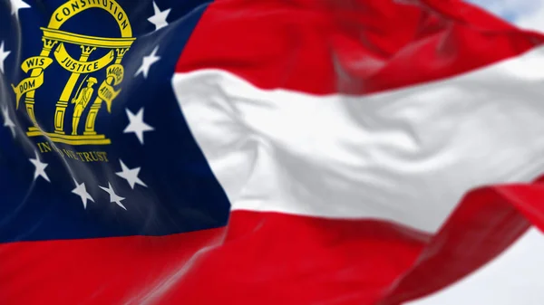 Close-up of Georgia state flag waving in the wind on a clear day. Red, white, red stripes. Blue canton with 13 stars and coat of arms. 3d illustration render. Fluttering textile. Selective focus