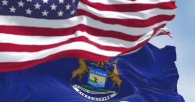 Açık bir günde Michigan ve Birleşik Devletler bayrakları rüzgarda sallanıyor. Vatanseverlik ve kimlik kavramı. Kusursuz 3 boyutlu animasyon. Yavaş çekim döngüsü. Seçici odaklanma. 4k