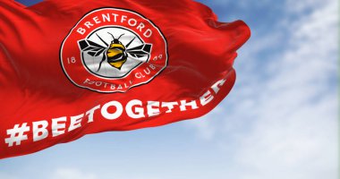 Londra, İngiltere, 19 Şubat 2023: Açık bir günde Brentford Futbol Kulübü bayrağı dalgalanmaktadır. Kırmızı üzerinde arı olan dairesel bir amblem. Resimli 3d illüstrasyon oluşturucu