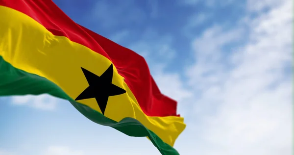 stock image National flag of Ghana waving on a clear day. Three equal horizontal stripes, red, yellow with black star, green, pan-African colors. 3d illustration render. Fluttering fabric. Selective focus