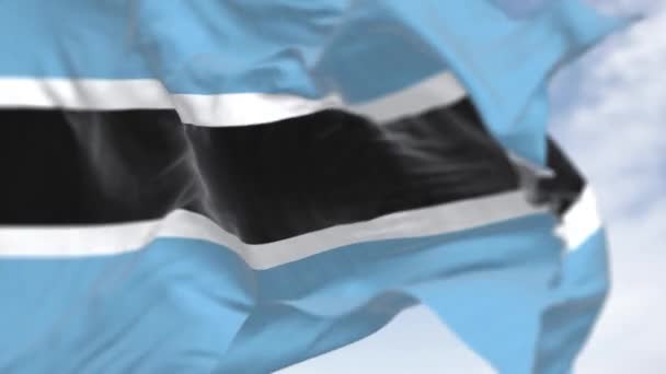 在一个晴朗的日子里 博茨瓦纳国旗飘扬的特写 中心为浅蓝色 有水平的黑白条纹 无缝3D渲染动画 慢动作回圈有选择的重点 — 图库视频影像