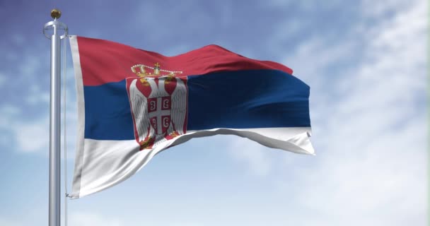 セルビアの国旗は晴れた日に風を吹いている 白のバンドは 中央の左側にセルビアの紋章を施した シームレスな3Dレンダリングアニメーションループ スローモーション — ストック動画