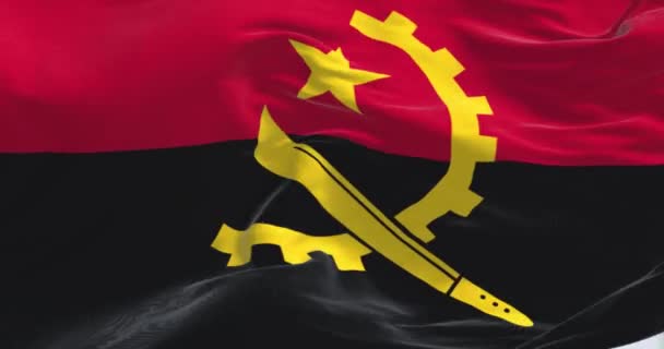 アンゴラの国旗が風に揺れている 2つの水平バンド 赤と黒 中央に黄色のエンブレム シームレスな3Dレンダリングアニメーションループ スローモーション — ストック動画