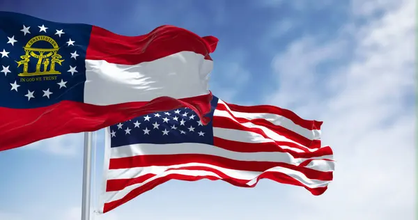 The flags of Georgia and United States waving in the wind on a clear day. Georgia is a state in the southeastern US. US federate state. 3d illustration render. Fluttering textile