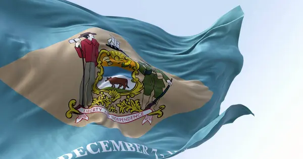 Delaware state flag waving on a clear day. Colonial blue background with a buff-colored diamond and state coat of arms, and December 7, 1787 below it. 3d illustration render. Fluttering fabric
