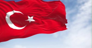 Türk ulusal bayrağı açık bir günde rüzgarda dalgalanıyor. Beyaz hilalli kırmızı bayrak ve bir yıldız. Kusursuz 3D canlandırma döngüsü. Yavaş çekim.