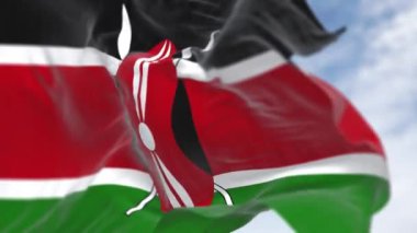 Kenya ulusal bayrağının dalgalandığı yakın çekim. Siyah, kırmızı ve yeşil bantlar, ortasında iki mızrak olan siyah bir Masai kalkanı. Kusursuz 3D canlandırma döngüsü. Ağır çekim. Seçici odak
