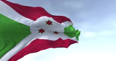 Burundi ulusal bayrağı açık havada sallanıyor. Kırmızı ve yeşil bölümlere bölünen beyaz köşegen, ortada üç yeşil yıldız. Kusursuz 3D canlandırma döngüsü. Yavaş çekim.