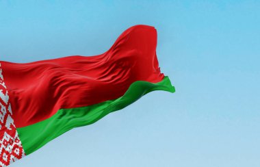 Belarus 'un ulusal bayrağı açık bir günde rüzgarda sallanıyor. Beyaz ve kırmızı süslemeli kırmızı ve kırmızı bayrak. Personel bitiş çizimine yerleştirilmiş. Dalgalanan tekstil