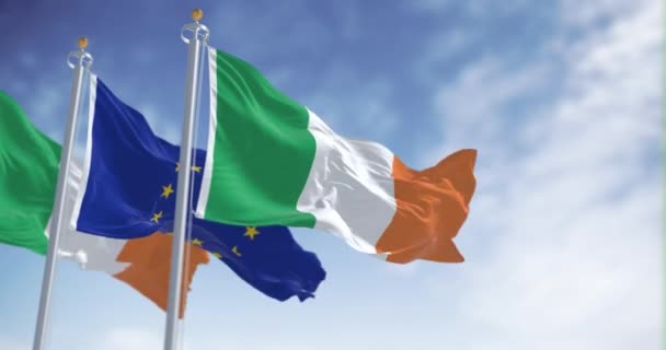 アイルランドと欧州連合の旗が晴れた日を迎えます アイルランドは1973年に欧州連合に加盟した シームレス3Dレンダリングアニメーション スローモーションループ 選択的な焦点 リッピングファブリック — ストック動画