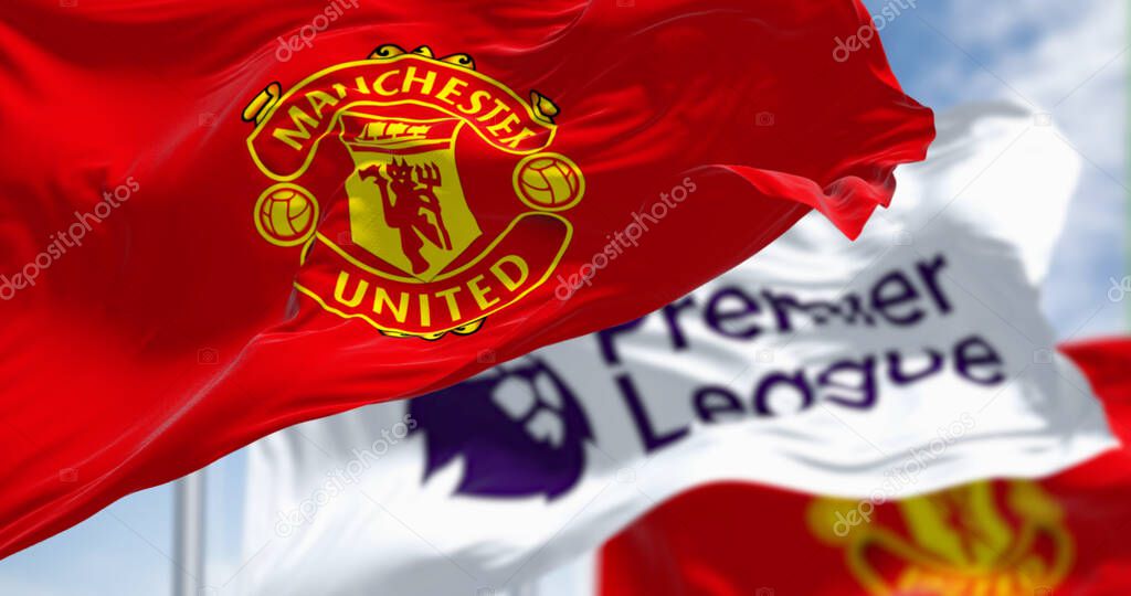 Manchester, UK, July 2 2023: Manchester United Football Club and Premier League flags waving on a clear day. Premier League pro team. Illustrative editorial 3d illustration render. Selective focus