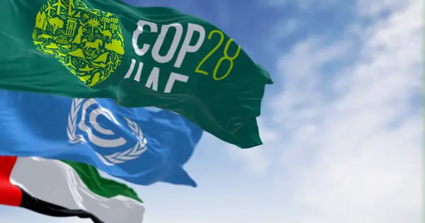 stock image Dubai, UAE, Nov. 30 2023: Flags of COP28, UNFCCC and UAE waving on a clear day. 3d illustration render. Selective focus. Rippling fabric