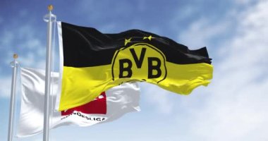 Dortmund, DE, 10 Kasım 2023: Borussia Dortmund bayrağı açık bir günde Bundesliga bayrağıyla dalgalanıyor. Profesyonel Alman futbol kulübü. Kusursuz 3 boyutlu animasyon. Yavaş çekim döngüsü. Sallanan bayrak