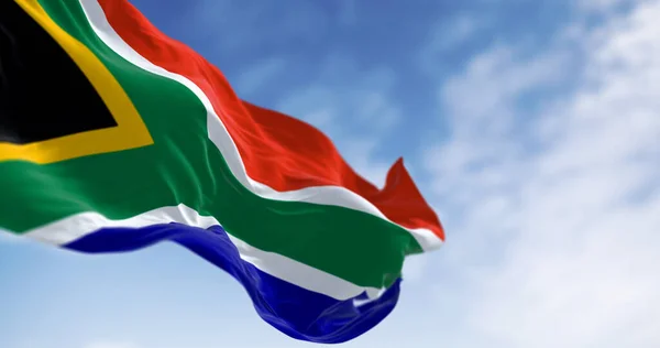 stock image Detail of the South Africa flag waving. Red and blue flag divided by a green Y that encloses a black triangle with a yellow border. 3d illustration render. Selective focus. Close-up.