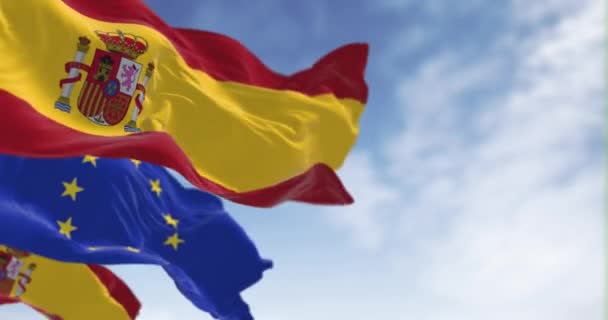 スペインの国旗は 明確な日に欧州連合の旗を掲げています 国際協力 シームレス3Dレンダリングアニメーション スローモーションループ 選択的な焦点 ウィングフラッグ — ストック動画