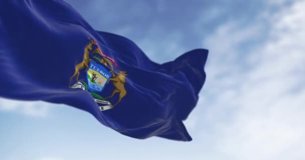 ミシガン州の国旗が晴れた日 イーグル エルカ ムースをフィーチャーした国章付きのダークブルーの旗 シームレス3Dレンダリングアニメーション スローモーションループ 選択的な焦点 ウィングフラッグ — ストック動画