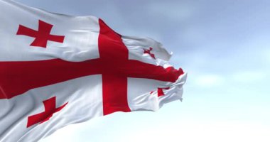 Açık bir günde rüzgarda sallanan Gürcistan bayrağı. Kırmızı haçlı beyaz, her çeyrekte dört küçük haç. Kusursuz 3 boyutlu animasyon. Yavaş çekim döngüsü. Sallanan bayrak