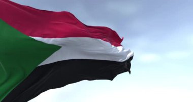 Sudan ulusal bayrağının rüzgarda dalgalanan yakın çekimi. Kırmızı, beyaz, siyah yatay çizgiler ve kaldırma yerinde yeşil bir üçgen. Kusursuz 3 boyutlu animasyon. Yavaş çekim döngüsü. Seçici odak