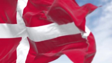 Açık bir günde Danimarka ulusal bayrağının yakın çekimi. Bayrağın kenarına uzanan beyaz İskandinav haçı olan kırmızı bayrak. Kusursuz 3 boyutlu animasyon. Yavaş çekim döngüsü. Seçici odak