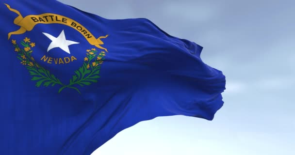 晴れた日に風を吹くネバダ州旗の閉鎖 左上に州のエンブレムが付いているコバルトブルーフィールド シームレス3Dレンダリングアニメーション スローモーションループ — ストック動画