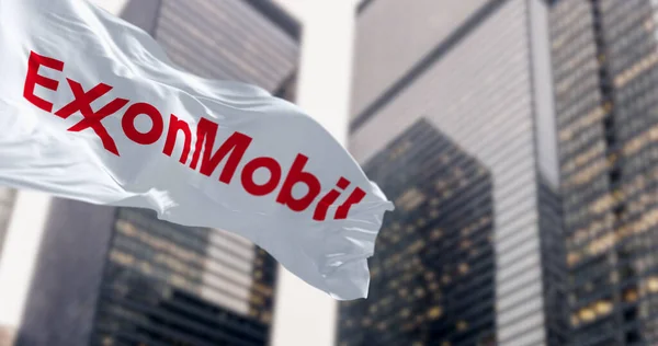stock image Spring, US, Oct. 5 2023: ExxonMobil flag waving in the wind in a financial district. American multinational oil and gas corporation. Illustrative editorial 3d illustration render