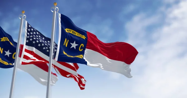North Carolina state flags waving with american flag. North Carolina is a state in the Southeastern region of the S. Rippled fabric. 3d illustration render. Selective focus. Rippling fabric