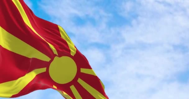 在晴朗的日子里 北马其顿的国旗飘扬着 黄色的太阳 八道光芒延伸到红场的边缘 无缝3D渲染动画 慢动作回圈有选择的重点 — 图库视频影像