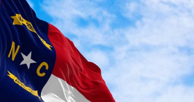 North Carolina state flag waving. North Carolina is a state in the Southeastern region of the United States. Rippled fabric. 3d illustration render. Selective focus. Close-up.