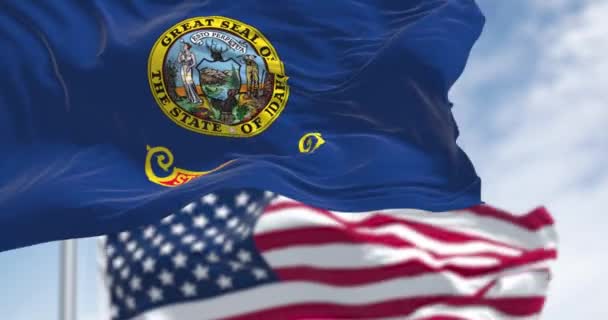 アイダホ州旗は明確な日にアメリカ合衆国の国旗と共に掲げられている シームレス3Dレンダリングアニメーション スローモーションループ 選択的なフォーカス — ストック動画