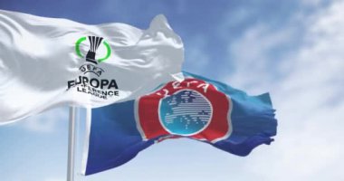 Atina, GR, 15 Aralık 2024: UEFA ve UEFA Avrupa Konferans Ligi logosu dalgalanan bayraklar. Belgesel Editörü. Kusursuz 3 boyutlu animasyon. Yavaş çekim döngüsü. Seçici odak