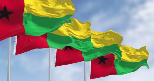 几内亚比绍的国旗在一个晴朗的日子飘扬 垂直的红色条纹 黑色的左边 黄色和绿色的水平条纹右边 无缝3D渲染动画 慢动作回圈有选择的重点 — 图库视频影像