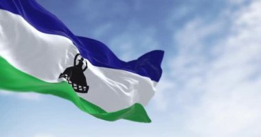 Açık bir günde ulusal Lesotho bayrağı sallanıyor. Ortasında siyah bir Basotho şapkası olan üç yatay mavi, beyaz ve yeşil şerit. Kusursuz 3 boyutlu animasyon. Yavaş çekim döngüsü. Seçici odak