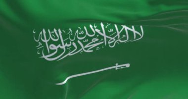 Suudi Arabistan ulusal bayrağının rüzgarda dalgalanan yakın çekimi. Shahada 'lı yeşil alan ve Thuluth senaryosunda kılıç. Dalgalı kumaş. Kusursuz 3 boyutlu animasyon. Yavaş çekim döngüsü.
