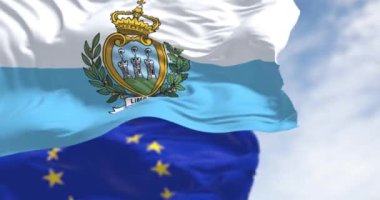 Açık bir günde San Marino ve Avrupa Birliği bayrakları rüzgarda sallanıyor. Avrupa mikro durumu. Kusursuz 3 boyutlu animasyon. Yavaş çekim döngüsü. Seçici odak