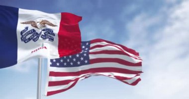 Iowa eyaleti bayrağı açık bir günde Amerikan bayrağıyla rüzgarda sallanıyor. Kusursuz 3 boyutlu animasyon. Yavaş çekim döngüsü. Seçici odak