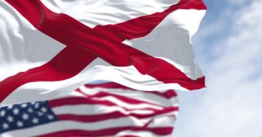 Güneşli bir günde Birleşik Devletler ve Alabama bayrakları birlikte dalgalanıyor. Alabama bayrağında beyaz bir tarlada kırmızı bir haç var. Kusursuz 3 boyutlu animasyon. Yavaş çekim döngüsü. Seçici odak