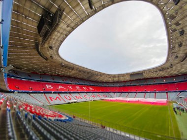 Münih, DE, 22 Aralık 2022; FC Bayern Münih 'in ev sahibi stadyumu Allianz Arena' nın boş iç mekanı, ikonik kırmızı koltukları ve sahayı gösteriyor. Arena yaklaşan bir etkinlik için hazırlandı.