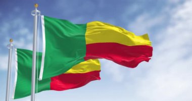 İki Benin ulusal bayrağı dalgalanıyor. Uçan tarafta iki yatay sarı ve kırmızı şerit ve kaldırmada da yeşil dikey şerit. Kusursuz 3 boyutlu animasyon. Yavaş çekim döngüsü. Seçici odak