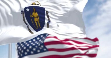 Massachusetts ve Amerika Birleşik Devletleri bayrakları açık bir günde rüzgarda sallanıyor. Vatanseverlik ve kimlik kavramı. Kusursuz 3 boyutlu animasyon. Yavaş çekim döngüsü. Seçici odak